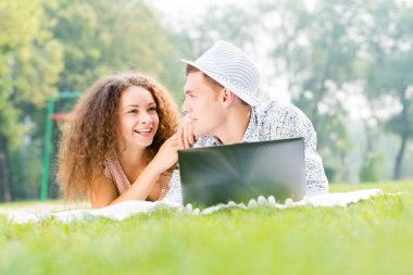 Çift birlikte parkta laptop ile yalan