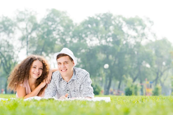 Couple lying on the grass in the summer park — Stock Photo, Image