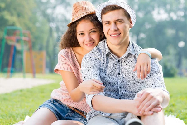 Couple lying on the grass in the summer park — Stock Photo, Image