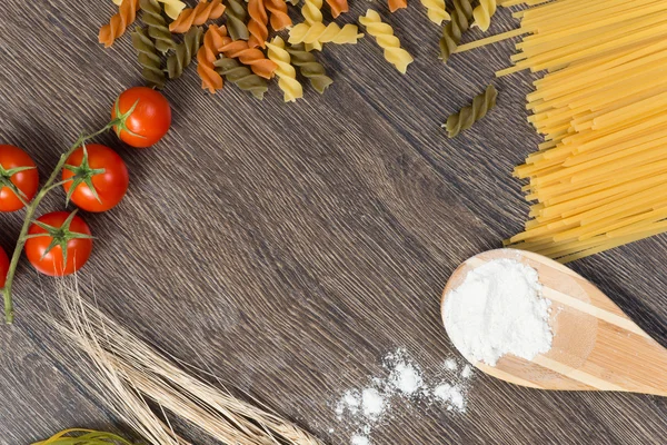 Pasta, tomatoes and flour on the spoon — Stock Photo, Image