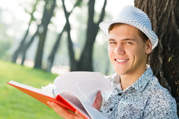 Unge man läser en bok — Stockfoto