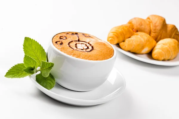 Grande xícara de café e croissants em uma placa — Fotografia de Stock