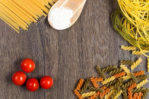 Pasta, tomatoes and flour on the spoon — Stock Photo, Image