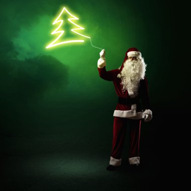 Santa Claus is holding a shining Christmas tree clipart