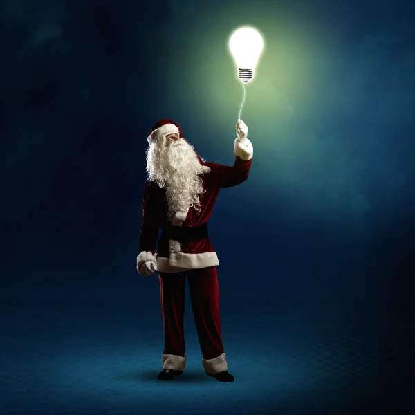 Santa Claus sostiene una lámpara brillante —  Fotos de Stock