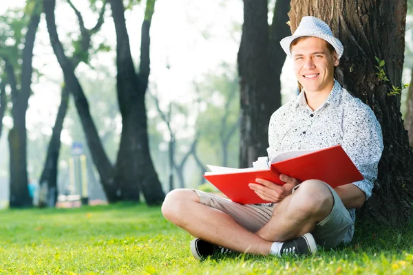 Unge man läser en bok — Stockfoto