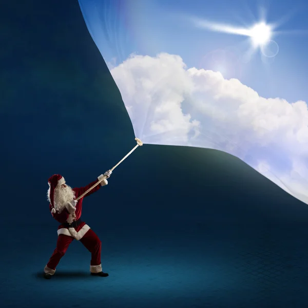 Santa Claus pulls the banner with day sky — Stock Photo, Image