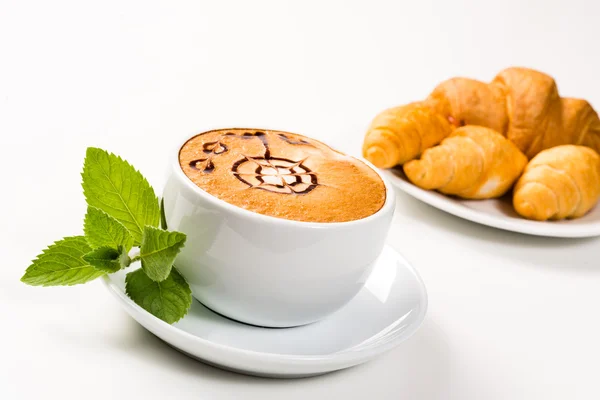 Grande xícara de café e croissants em uma placa — Fotografia de Stock