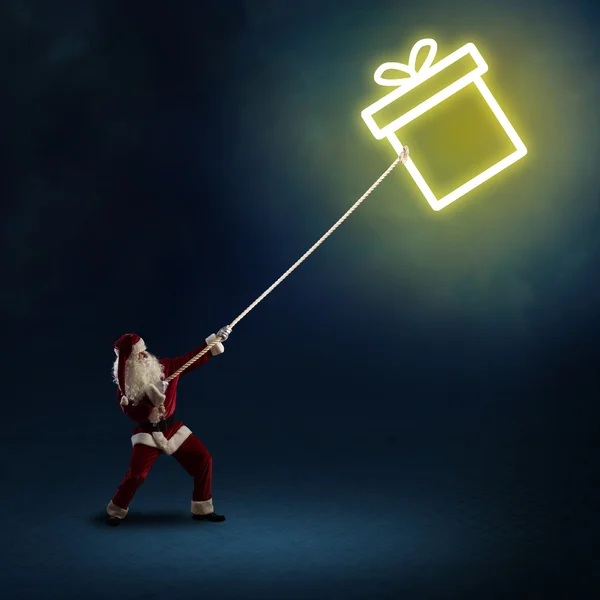 Babbo Natale tira una scatola simbolo con un regalo — Foto Stock