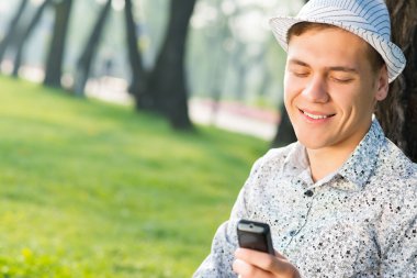 Cep telefonu olan genç bir adam.