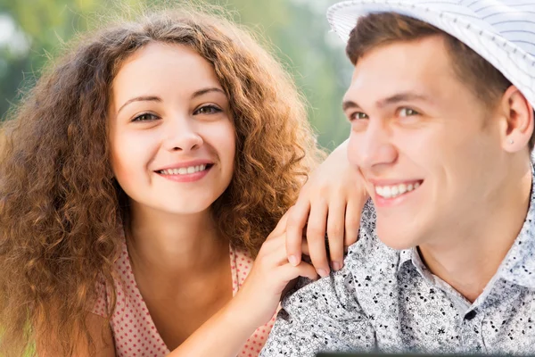 Paar liggen samen in een park met laptop — Stockfoto