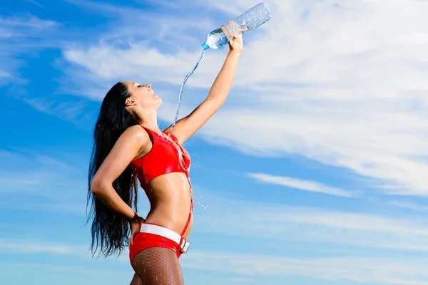 Sport girl in red uniform with a bottle of water — Stock Photo, Image