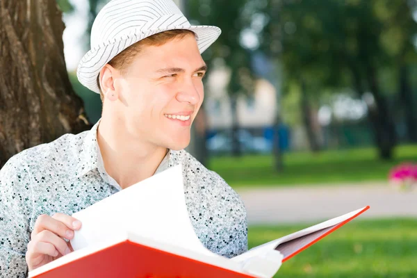 Unge man läser en bok — Stockfoto