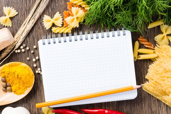 Spices and vegetables around notebook — Stock Photo, Image