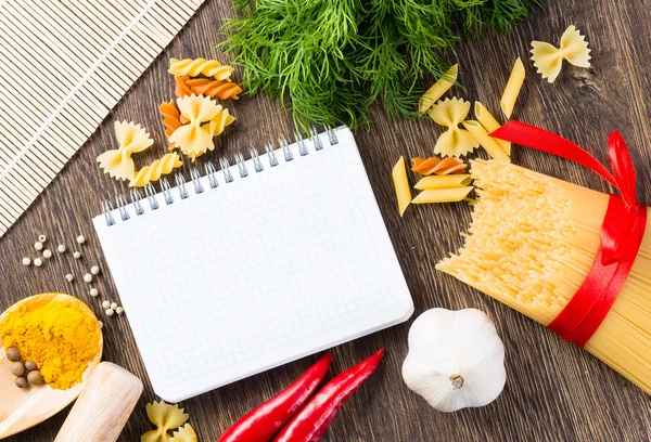 Spices and vegetables around notebook — Stock Photo, Image