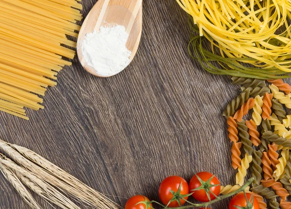 Pasta, tomatoes and flour on the spoon — Stock Photo, Image