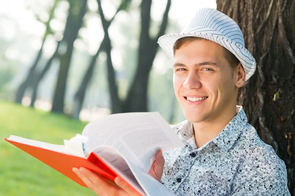 Unge man läser en bok — Stockfoto