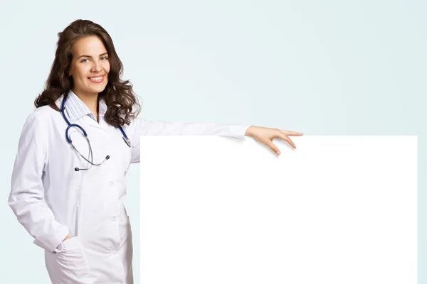 Young woman doctor with a blank banner — Stock Photo, Image