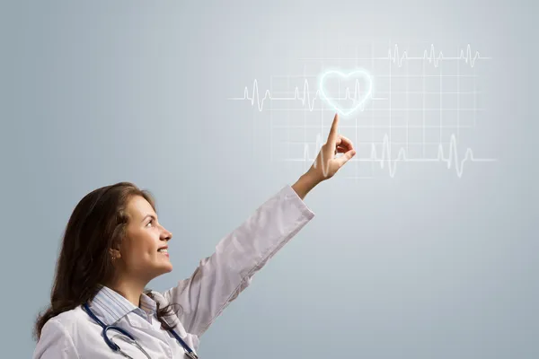 Young woman doctor finger glowing heart symbol — Stock Photo, Image