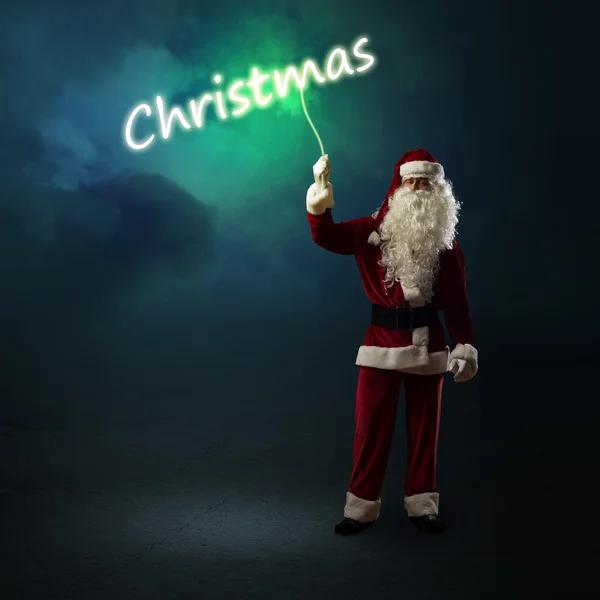 サンタ クロースが輝くクリスマス単語を保持しています。 — ストック写真
