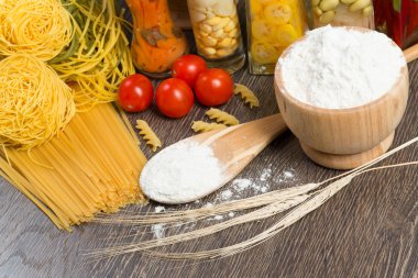 makarna, domates ve un üstünde kaşık