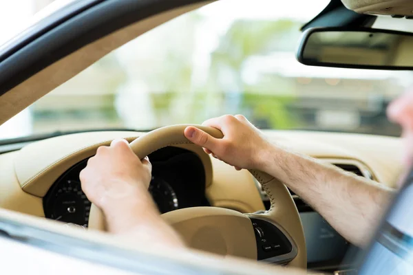Mão masculina segurando uma roda de carro — Fotografia de Stock