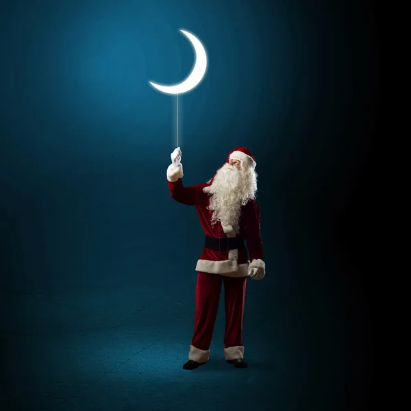 Santa Claus holding a shining moon — Stock Photo, Image