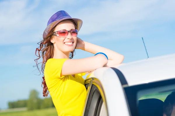 Jeune femme est sorti par la fenêtre de la voiture — Photo