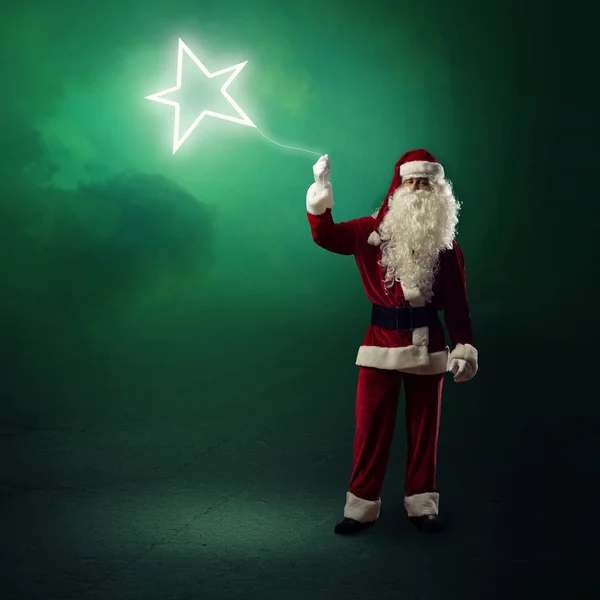 Santa Claus is holding a shining star — Stock Photo, Image