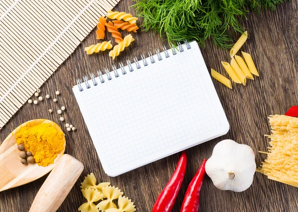 Spices and vegetables around notebook — Stock Photo, Image