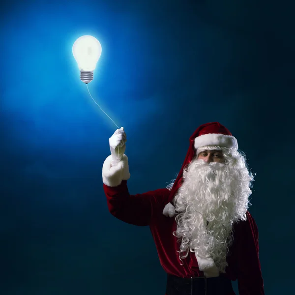 Papai Noel segurando uma lâmpada — Fotografia de Stock