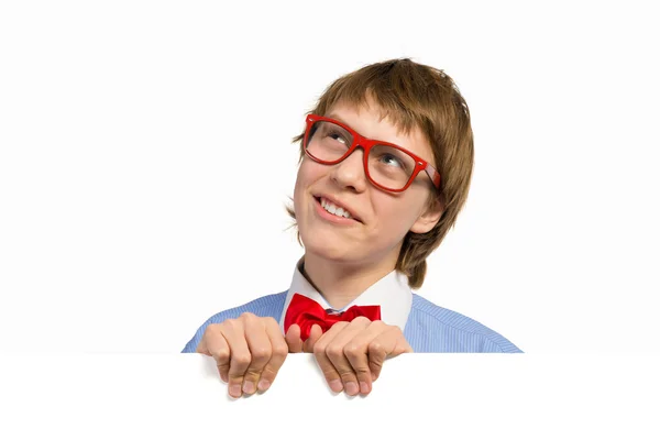 Menino com óculos segurando um cartaz branco — Fotografia de Stock