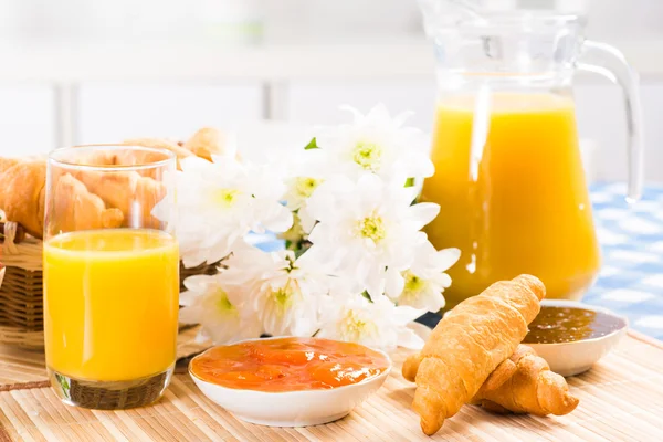 Tidig frukost, juice, croissanter och sylt — Stockfoto