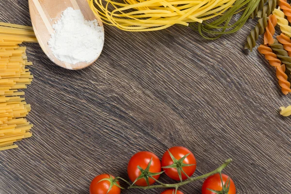 Pasta, tomatoes and flour on the spoon — Stock Photo, Image