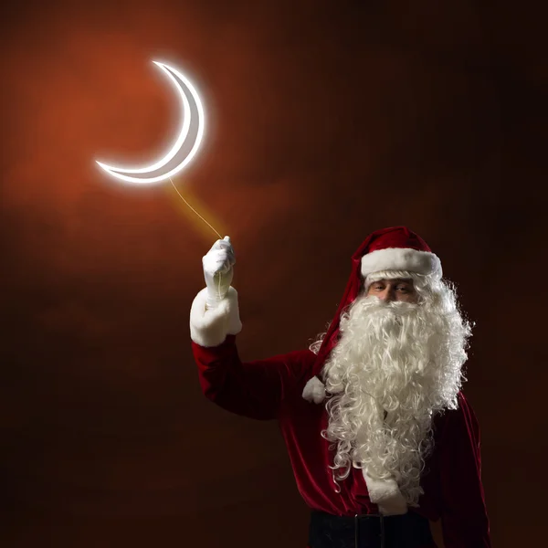 Santa claus houden een lichte symbool van de maan — Stockfoto