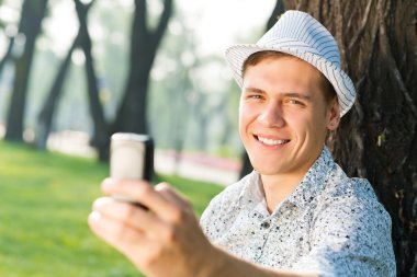 Cep telefonu olan genç bir adam.