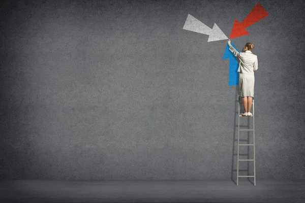 Zakelijke vrouw symbool van de pijlen op de muur — Stockfoto