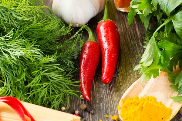 Chili, Kräuter und Gewürze liegen auf einer Holzoberfläche — Stockfoto