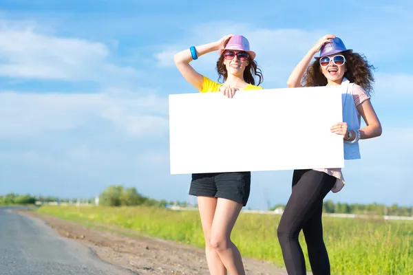 Mujeres de pie con una pancarta en blanco — Foto de Stock