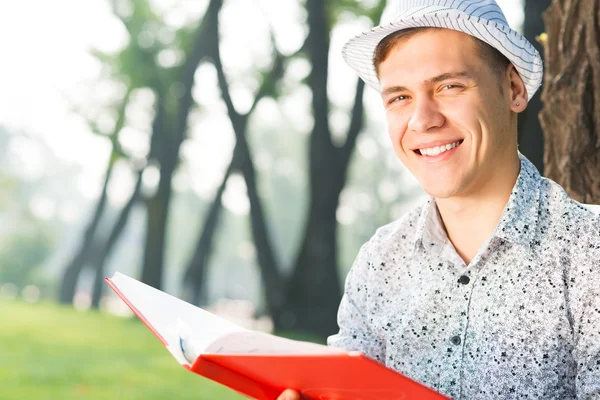 Unge man läser en bok — Stockfoto