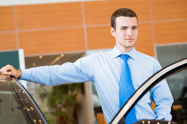 Dealer stands near a car — Stock Photo, Image