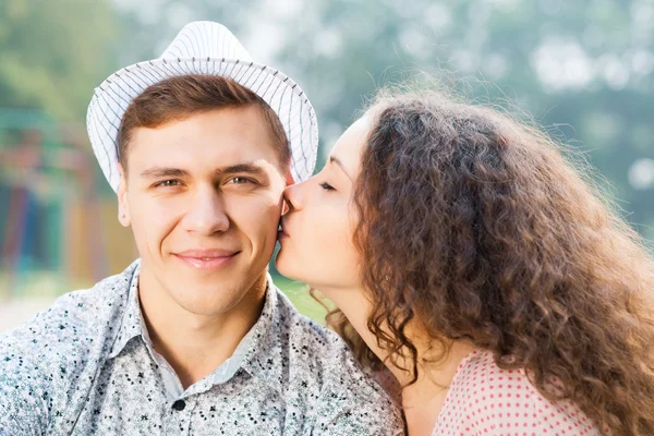 Girl kissing a man on the cheek — Stock Photo, Image