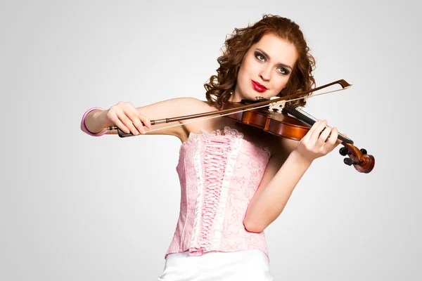 Женщина в корсете на скрипке — стоковое фото