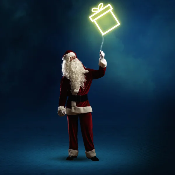 Santa Claus holding a gift — Stock Photo, Image