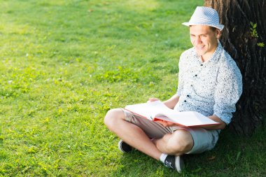 Genç adam kitap okuyor.