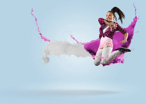 Young female dancer jumping with splash of paint — Stock Photo, Image