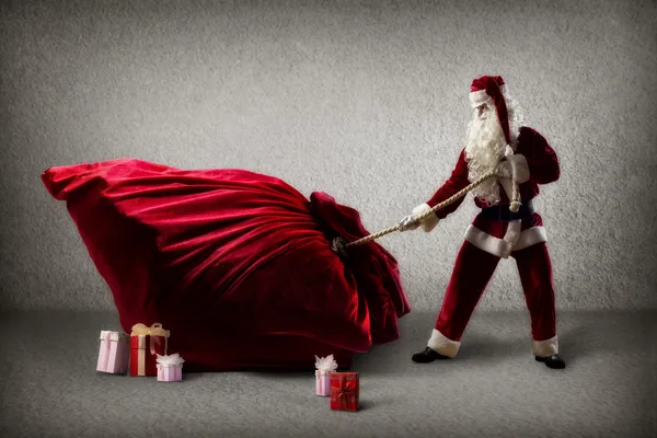 Santa Claus pulls a huge bag of gifts — Stock Photo, Image