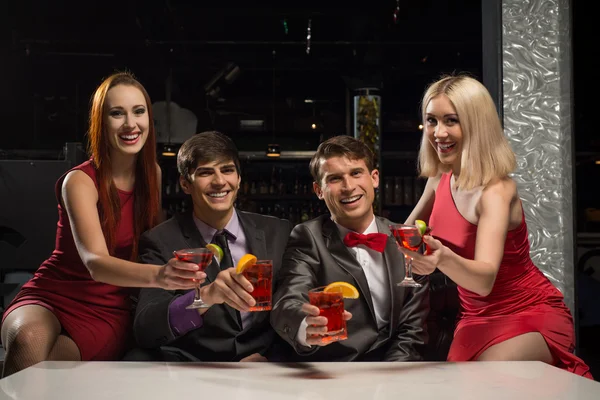 Männer und Frauen erhoben ihre Gläser mit Cocktails — Stockfoto