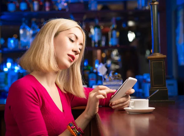 Femme avec une tasse de café et téléphone portable — Photo