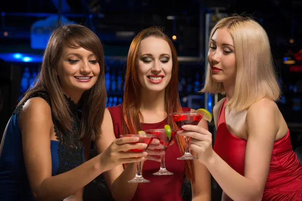 Three girls raised their glasses in a nightclub — Stock Photo, Image